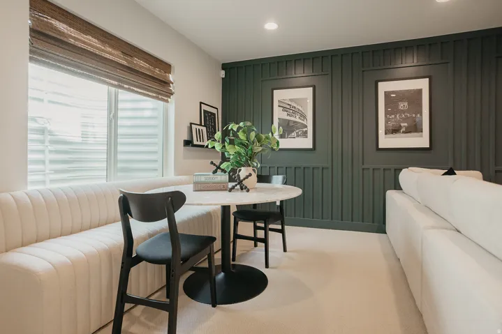 Built-in channel tufted seating, a round pedestal table, and recessed ceiling lighting