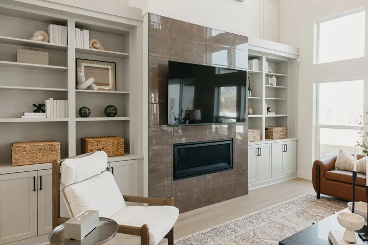 Built-in shelving units, integrated fireplace, expansive windows, wood-finish flooring, and high ceilings