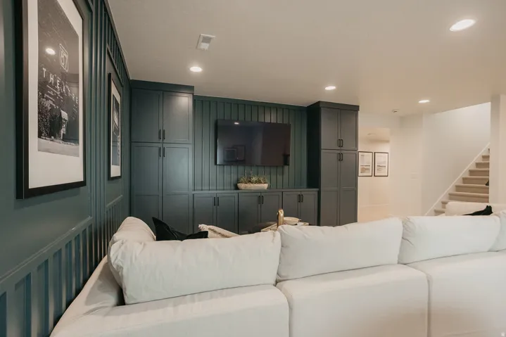 Built-in cabinetry with dark hardware, recessed lighting, and wall paneling
