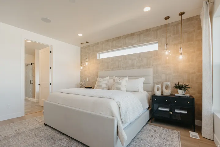 Feature wall with textured finish, recessed lighting, long horizontal window, and pendant lighting fixtures