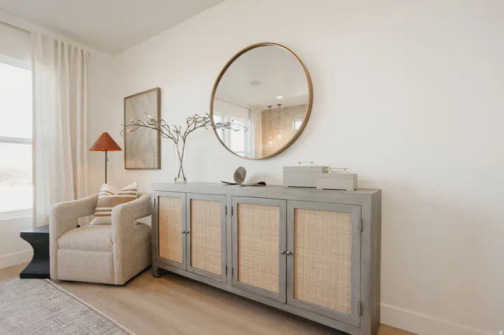 Wood-finish flooring, white walls, and a window with light-filtering drapery