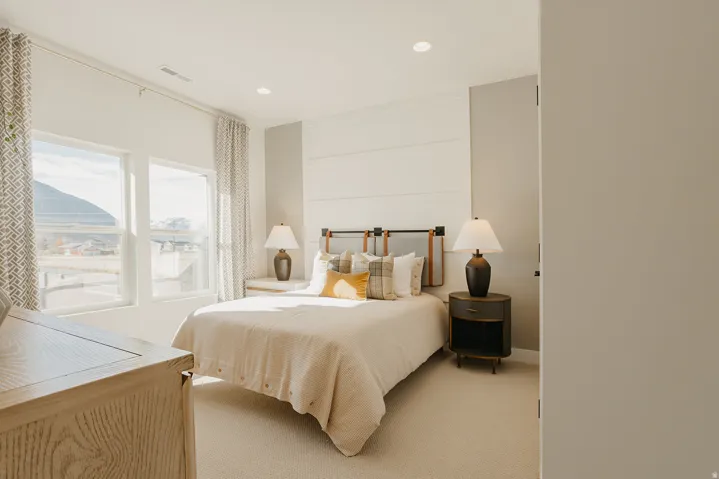 Expansive windows, recessed ceiling lighting, textured wall paneling, and neutral carpeting