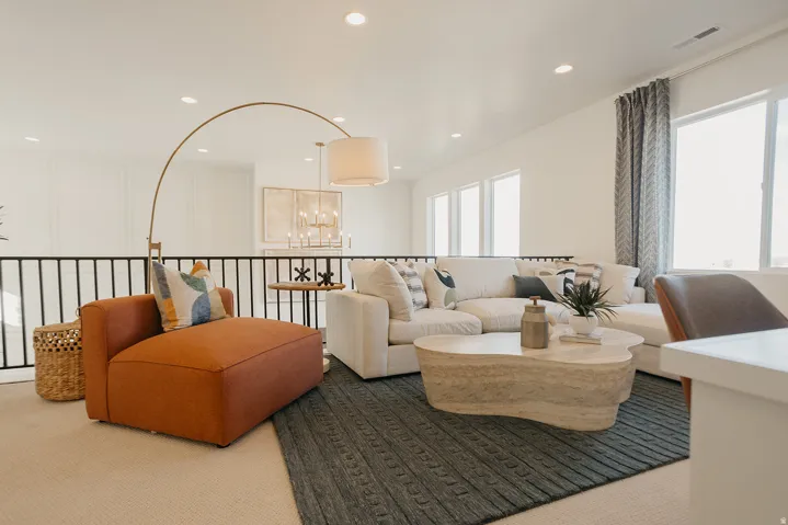 Bright open space with recessed lighting, large windows, and a black metal railing