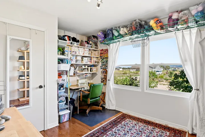 Hardwood-style flooring, white walls, and two large windows with white trim