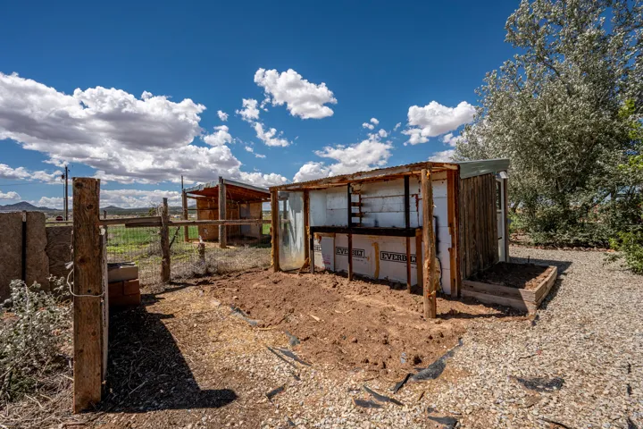 Wood-frame outbuilding featuring a sloped metal roof and an integrated workbench