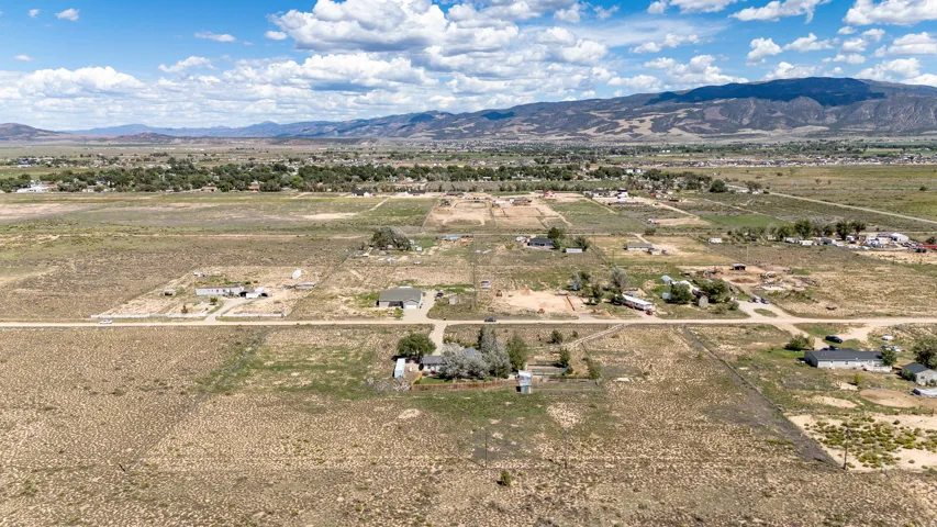 Expansive land area featuring scattered residential structures and distant mountain ranges