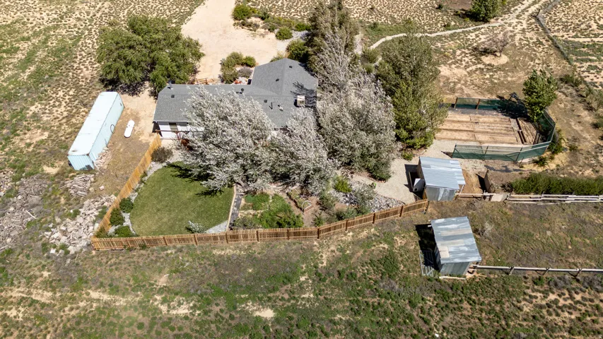 Expansive property featuring a private fenced yard, multiple outbuildings, and a large fenced enclosure