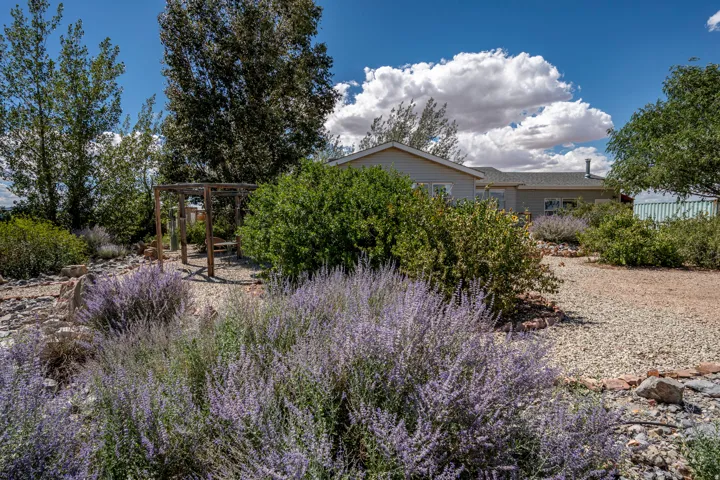 Landscaped grounds with a gravel pathway, mature trees, and flowering shrubs