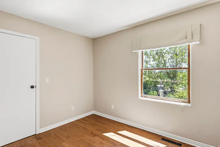 Wood-finish flooring with white trim and neutral wall color