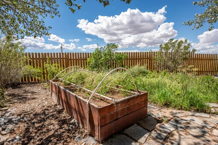 Raised garden bed with a wooden slatted privacy fence