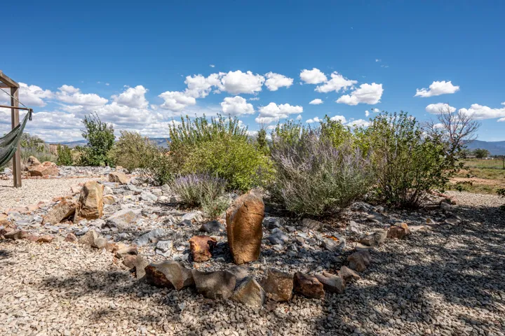 Xeriscape landscaping featuring decorative rock, stone accents, and established plantings