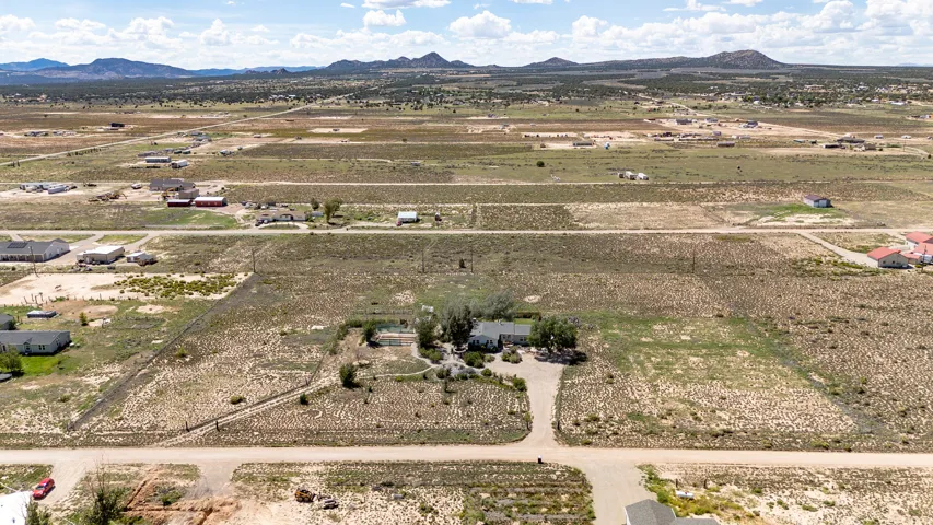 Expansive rural lot featuring a single-story residence, gravel driveway, and surrounding arid landscape