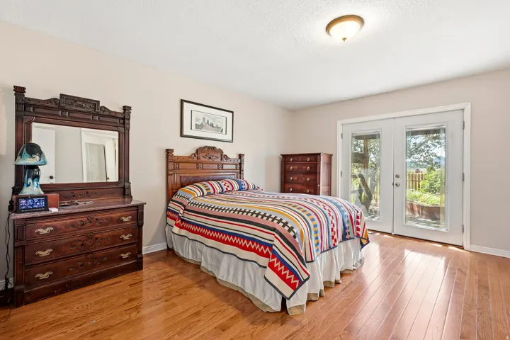 Hardwood flooring, painted walls, ceiling-mounted light fixture, and double glass-paneled doors