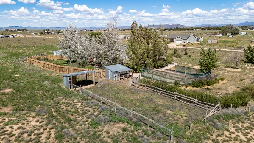 Extensive outdoor area featuring a wood fence, small outbuildings, and a split-rail fence