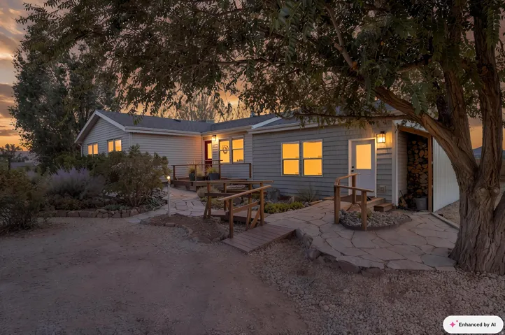 Siding exterior, multiple windows, stone pathway, wood deck, and an attached wood storage area