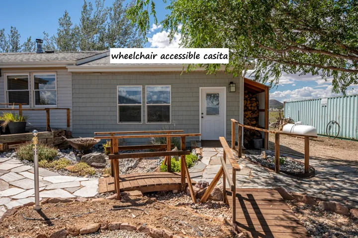 Casita with gray shingle siding, white entrance door, and dual pane windows