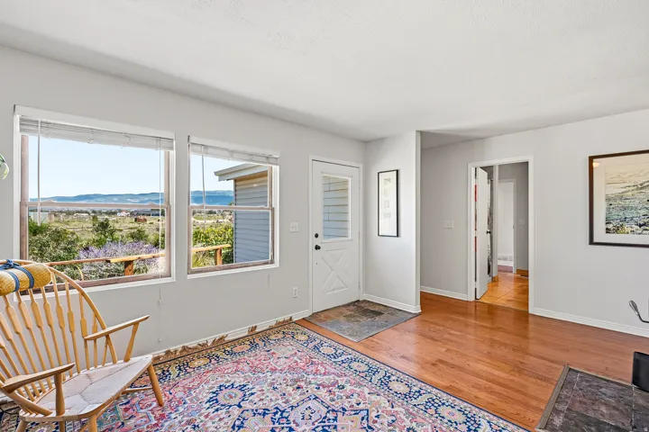 Hardwood flooring, white interior walls, multiple windows, solid core doors, white trim