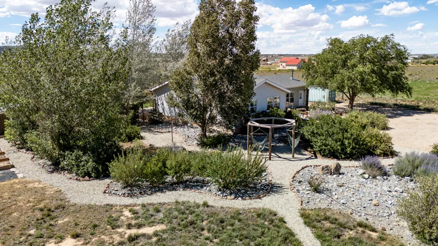 Manicured landscaping with gravel pathways, established trees, and varied plantings