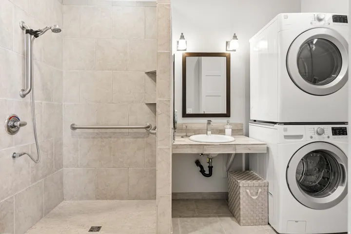 Tiled shower with grab bars and built-in shelving