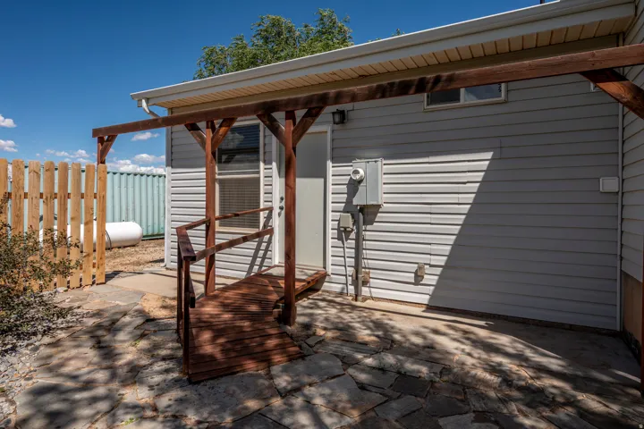 Exterior featuring horizontal siding, a wood-finish ramp, and flagstone paving