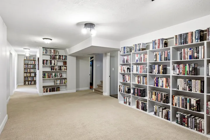 Built-in shelving, recessed lighting, and neutral carpet flooring
