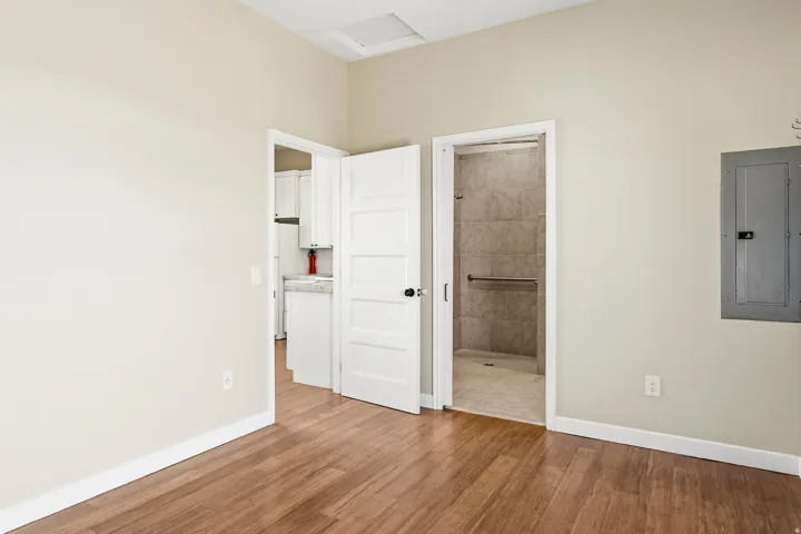 Wood-finish flooring throughout, neutral wall tones, and white trim