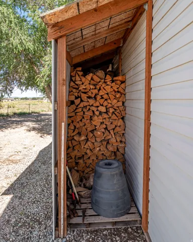 Wood storage shed with a sloped roof and gravel flooring