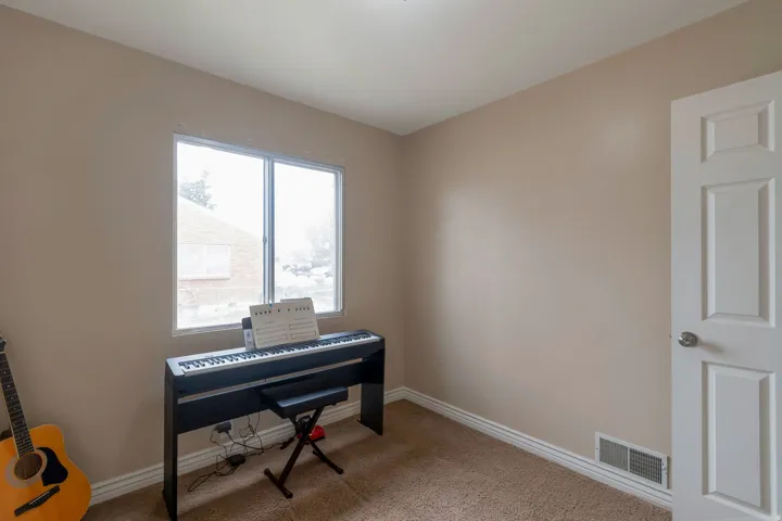 Neutral tone walls with white trim, brown carpet flooring, and a white paneled door
