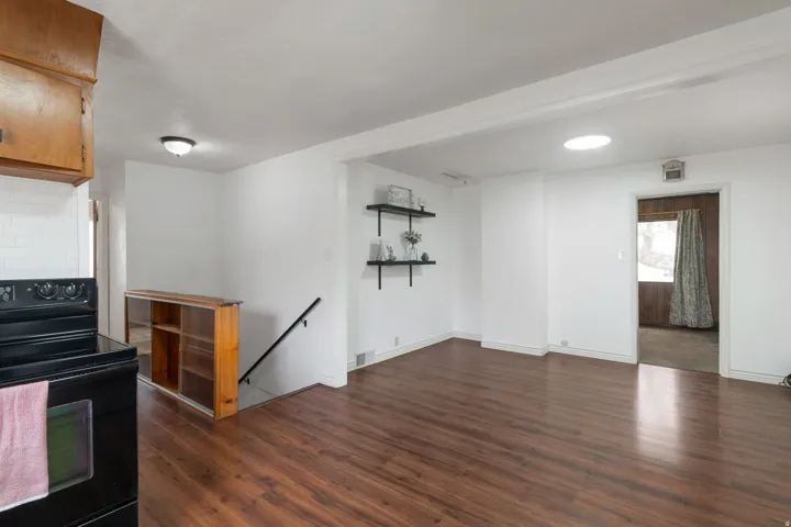 Wood-finish flooring throughout, white painted walls, recessed ceiling light, and built-in shelving