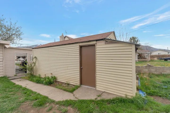 Detached accessory structure with horizontal siding and a brown entry door