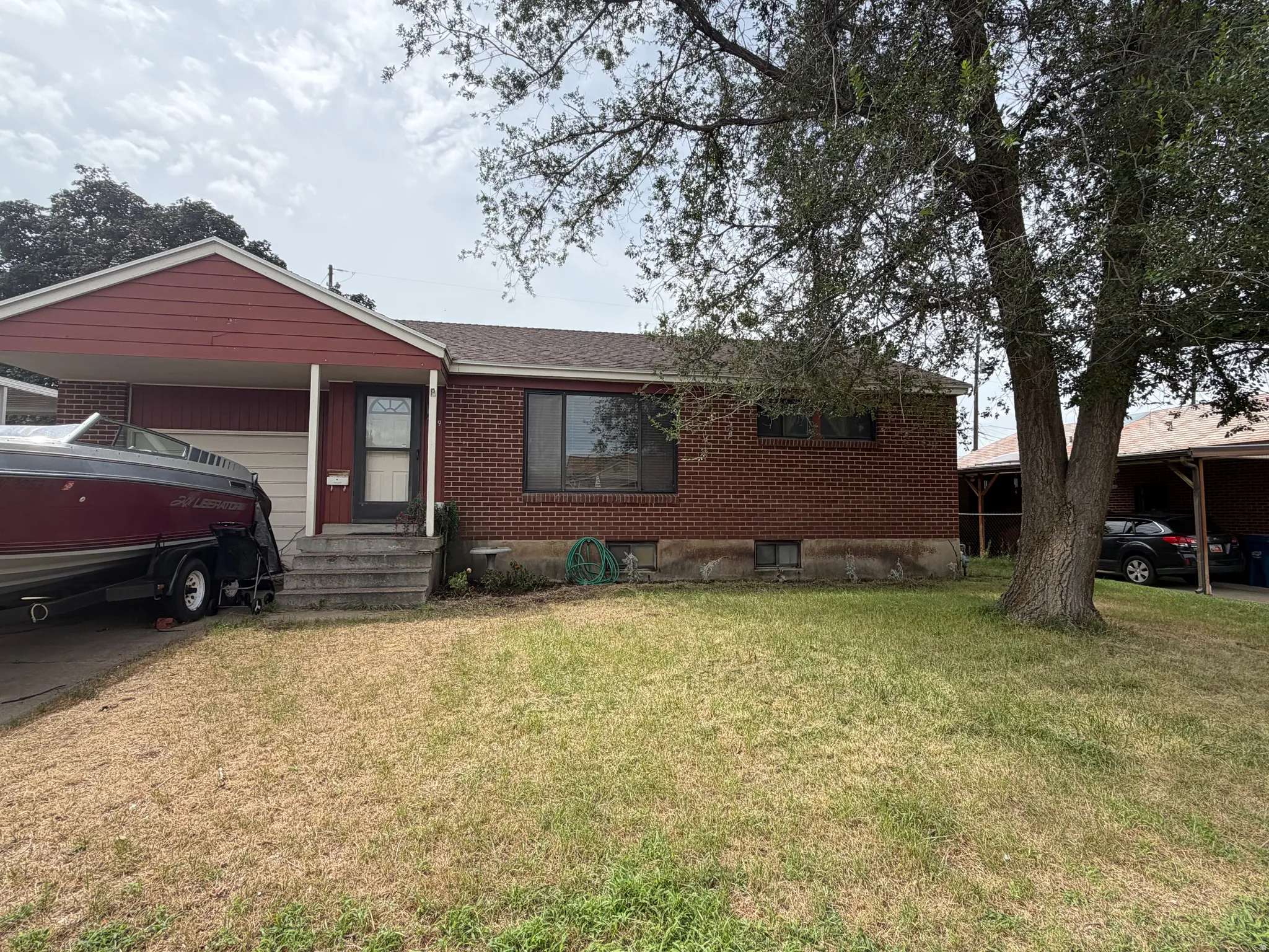 Brick exterior with a gabled roofline, covered entry, and attached carport