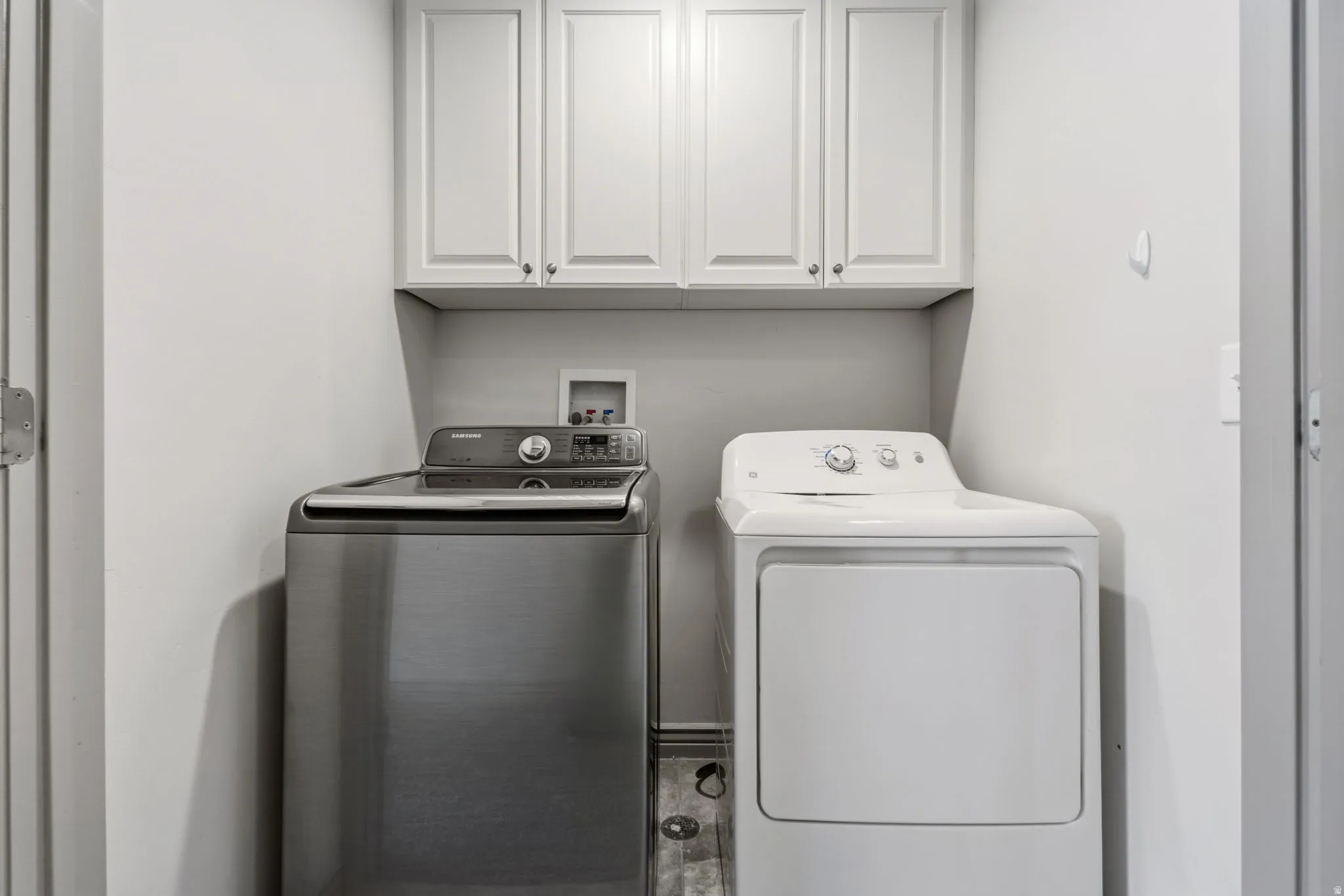 Laundry area featuring white shaker-style cabinetry