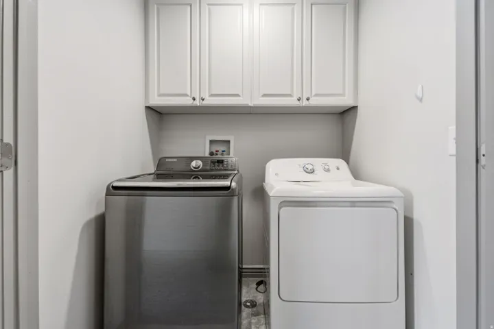 Laundry area featuring white shaker-style cabinetry