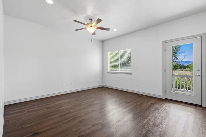 Spacious room featuring wood-finish flooring and a ceiling fan
