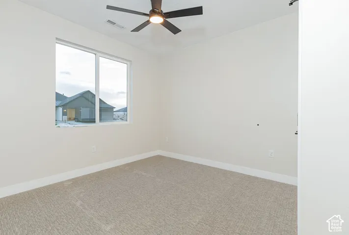 Neutral-toned carpet flooring, white walls, and a large window with white trim