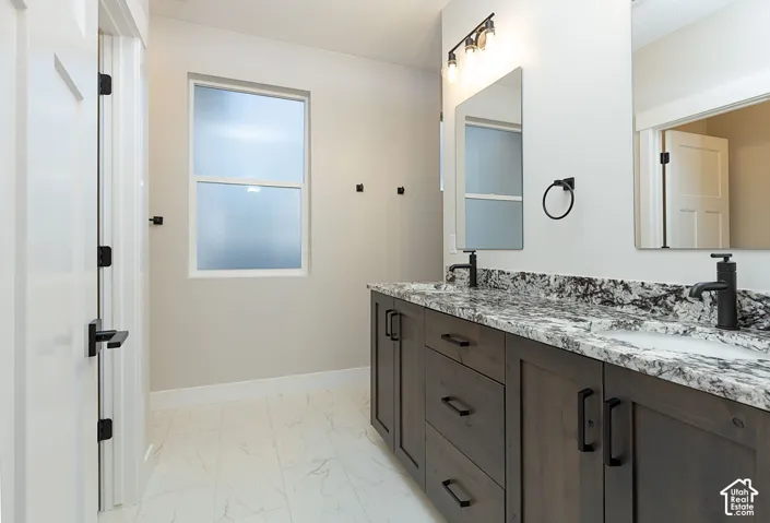 Dual vanity with stone countertop, undermount sinks, and matte black fixtures
