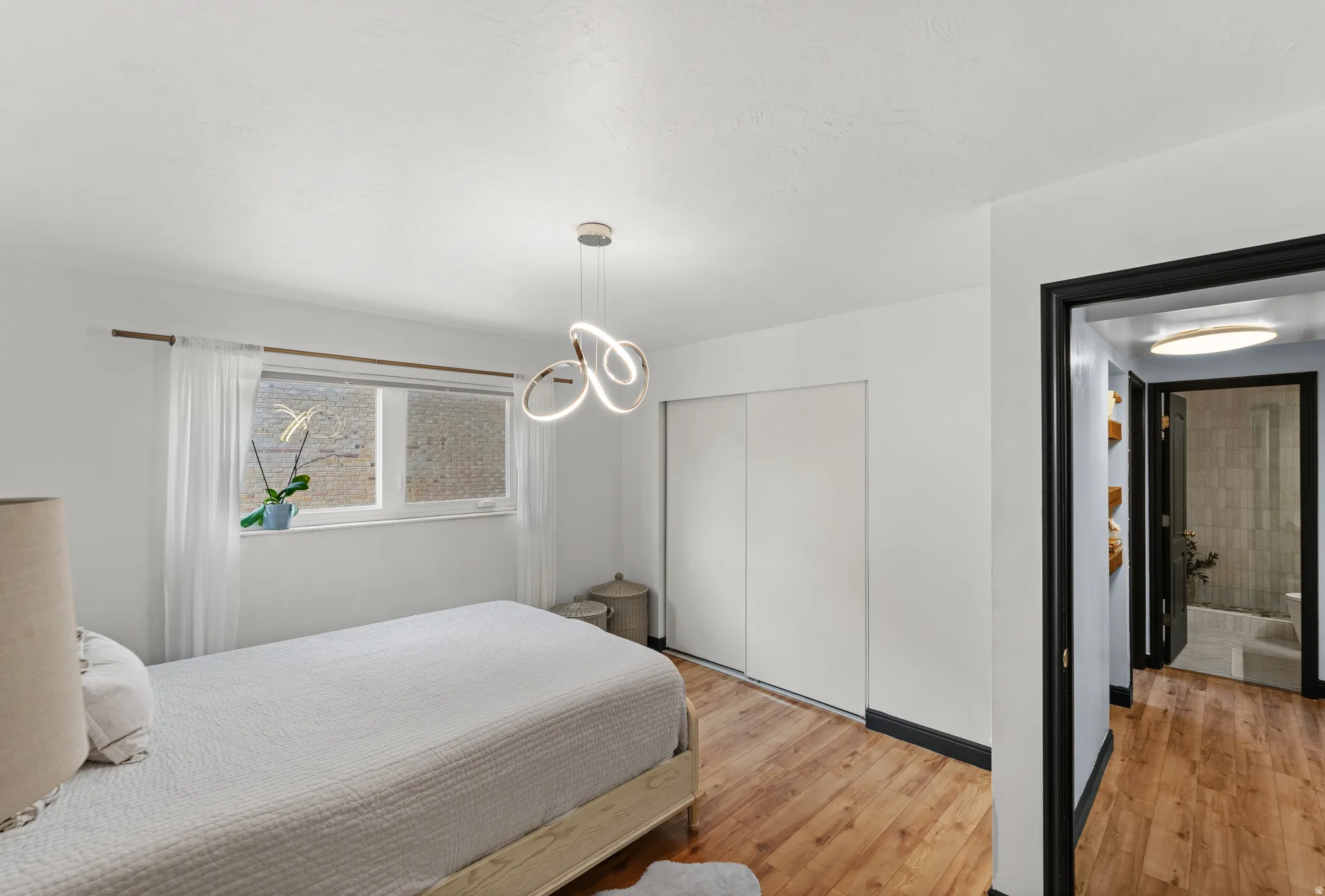 Wood-finish flooring, white walls, and a modern ceiling light fixture