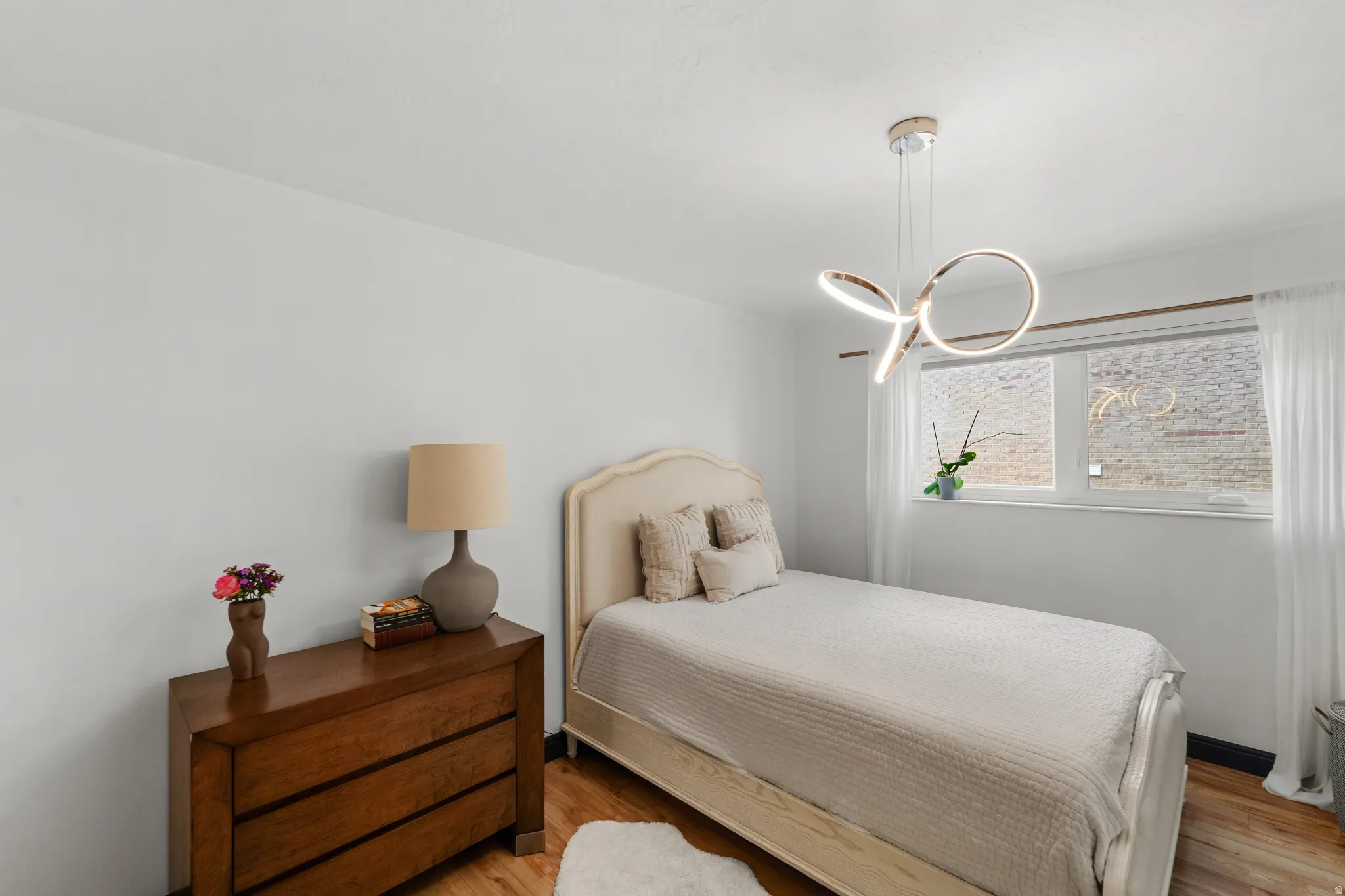 Wood-finish flooring, white walls, and a modern ceiling light fixture