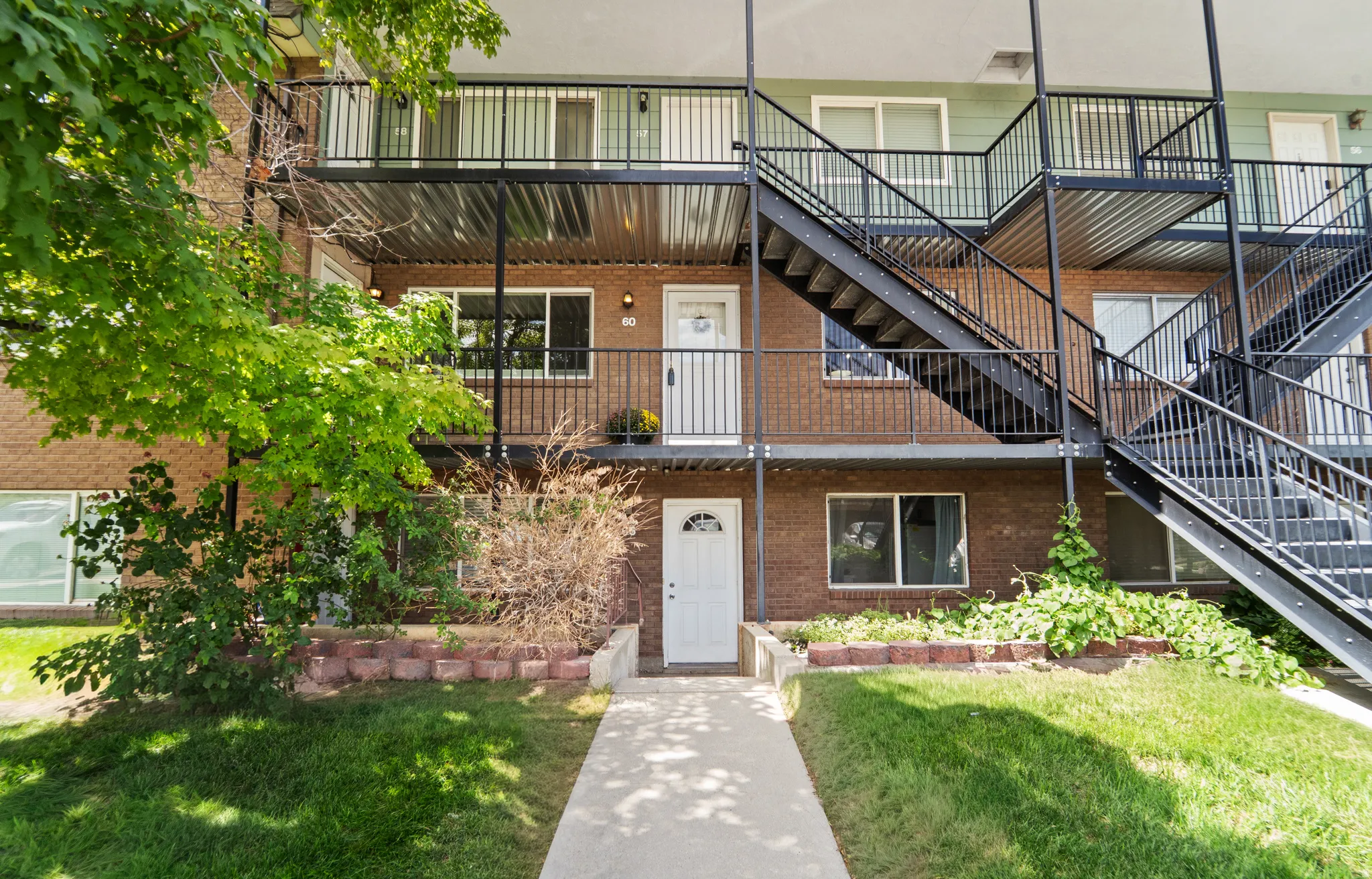 Brick exterior with multiple levels featuring black wrought-iron railings and exterior staircases