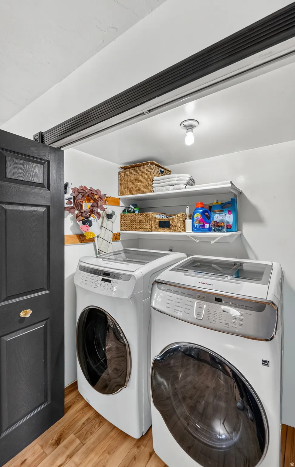 Dedicated laundry space with wood-finish flooring, white walls, and a recessed ceiling light