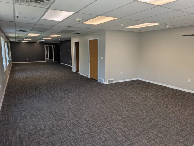 Second Floor expansive interior space featuring patterned carpet flooring, neutral paint tones, and multiple windows with blinds