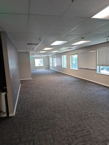 Second Floor expansive room with patterned carpet flooring, multiple windows, a whiteboard, and recessed ceiling lighting