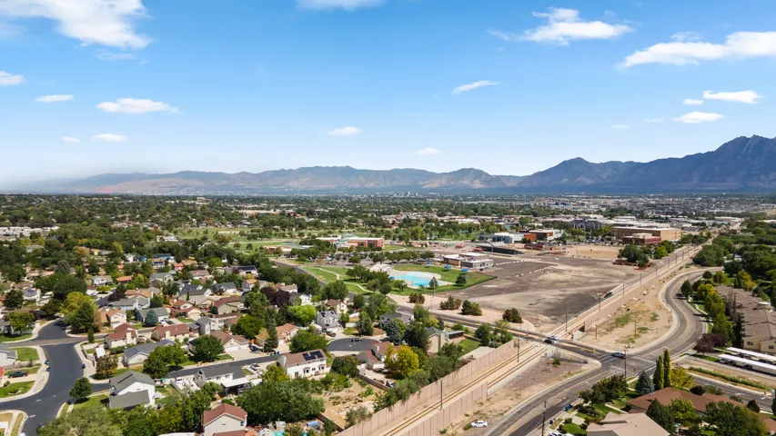 Expansive mountain range backdrop and a residential area with mature trees