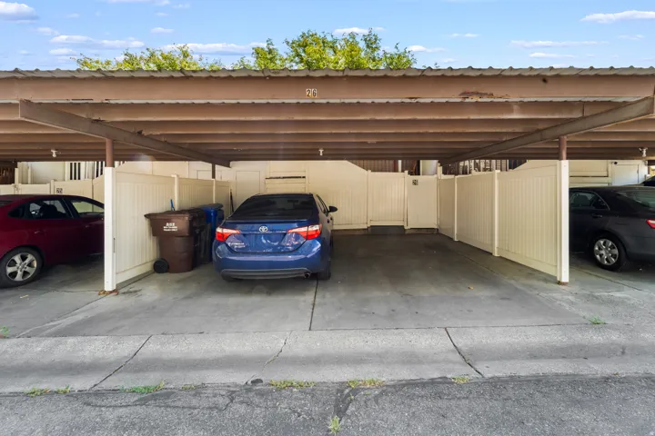 Covered parking structure with concrete flooring and privacy fencing