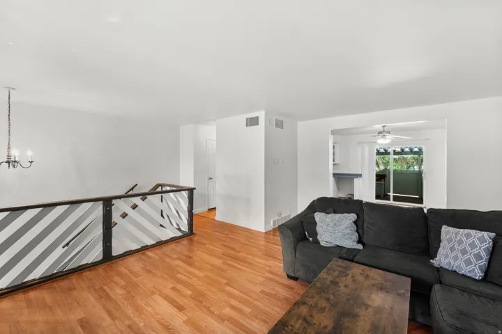 Wood-finish flooring throughout, with a decorative banister featuring diagonal accents