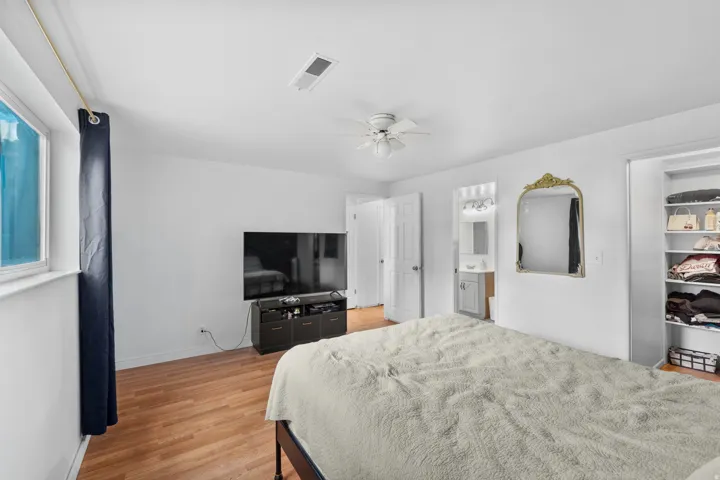 Wood-finish flooring, white walls, and a ceiling fan