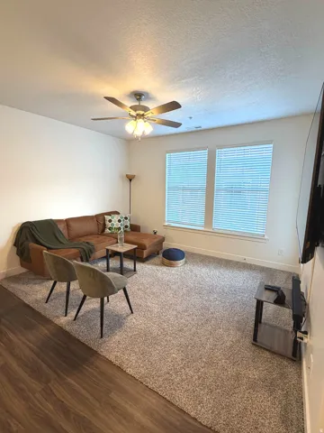 Wood-finish flooring, recessed lighting, ceiling fan, and dual windows with blinds