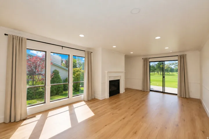 Wood-finish flooring, recessed lighting, and a fireplace with a classic mantel
