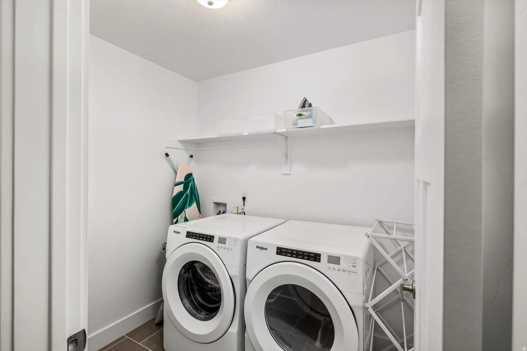 Dedicated laundry area featuring a shelf, overhead lighting, and tiled flooring