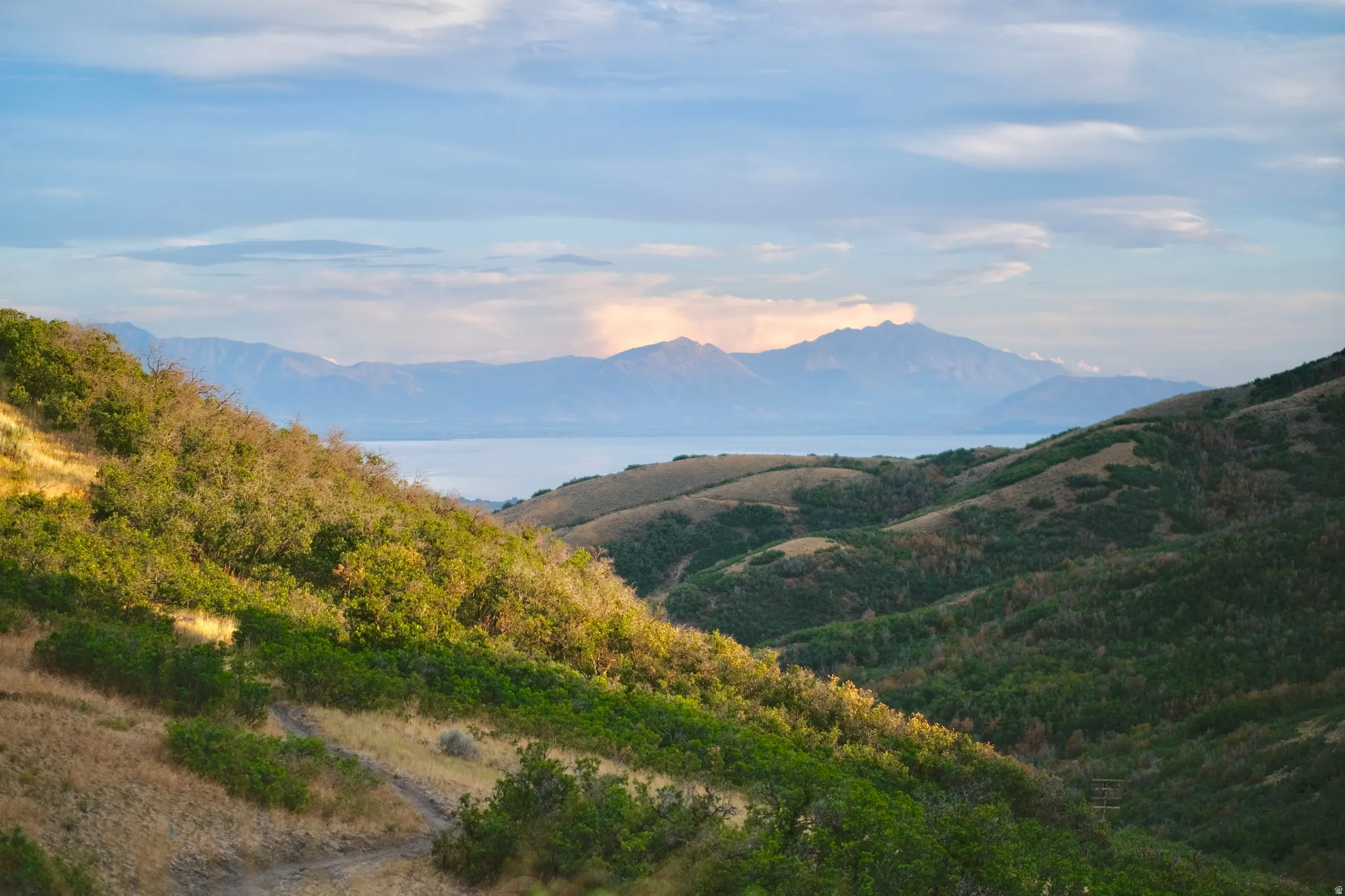 Sweeping views of Utah Lake from the surrounding SunCrest area, framed by rolling foothills and the Wasatch mountain landscape.